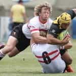 Two rugby players diving for the line in a tackle.