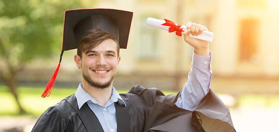 A graduate holding up a certificate.