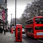 A red telephone box and a bus on a London street.