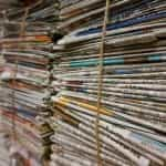 Stacks of newspapers bundled together with rope.