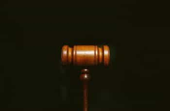 A wooden gavel sits on a black surface.