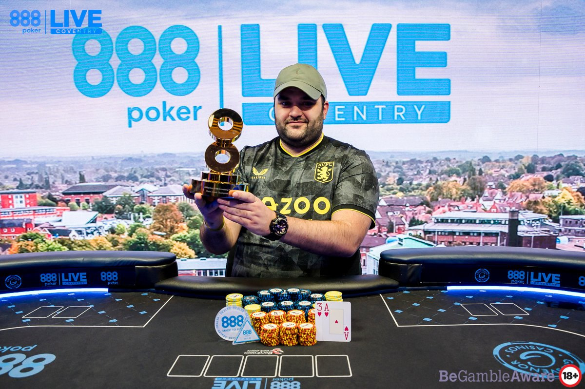 Poker player Yiannis Liperis shows off an 888poker winner’s trophy.